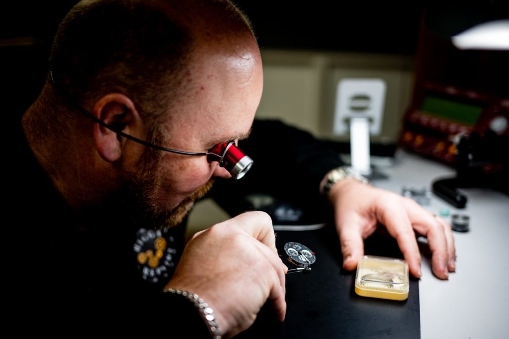 Detailed view of a watchmaker skillfully repairing a wristwatch in a workshop setting.